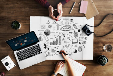 Laptop with the business plan on the table